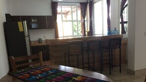 A kitchen with a dining table, chairs, and a refrigerator. - Tropical, private, safe brand new 3 bedroom home (panajachel)
