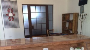 A kitchen with a wooden countertop, black cabinets, a decorative wall hanging, and a traditional Japanese sliding door. - Tropical, private, safe brand new 3 bedroom home (panajachel)