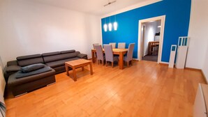 Un salon comprenant un canapé, une table basse en bois et un coin repas avec des chaises et une table.