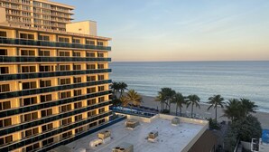 A hotel with a rooftop terrace overlooking the beach, featuring multiple balconies and air conditioning units. - Beach Front Building sits on the sand/ocean<br>  Newly  remodeled  beautiful condo<br> (Fort Lauderdale)