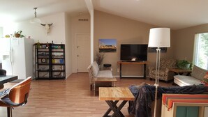 A living room with a sofa, a coffee table, a TV, and a bookshelf. - Explore Amador & Calaveras Counties. Kirkwood 45 minutes away. (West Point)