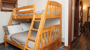 A bunk bed with a wooden frame, grey bedding, and a window with blinds. - Kingfield, Minneapolis; Sleeps 6; New Construction, 3 Miles from Downtown (Minneapolis)