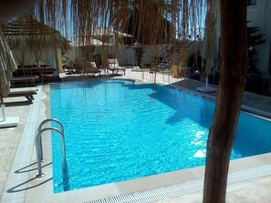 Una piscina al aire libre, tumbonas