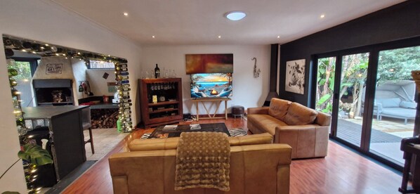 Una sala de estar moderna con un sofá, una mesa de centro, una chimenea y un ventanal con vistas al exterior.