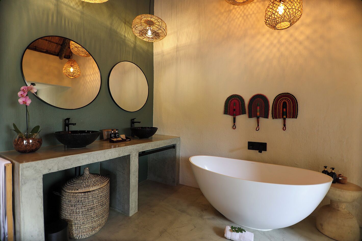 A modern bathroom with a large freestanding bathtub, a double sink vanity, and decorative wall art.