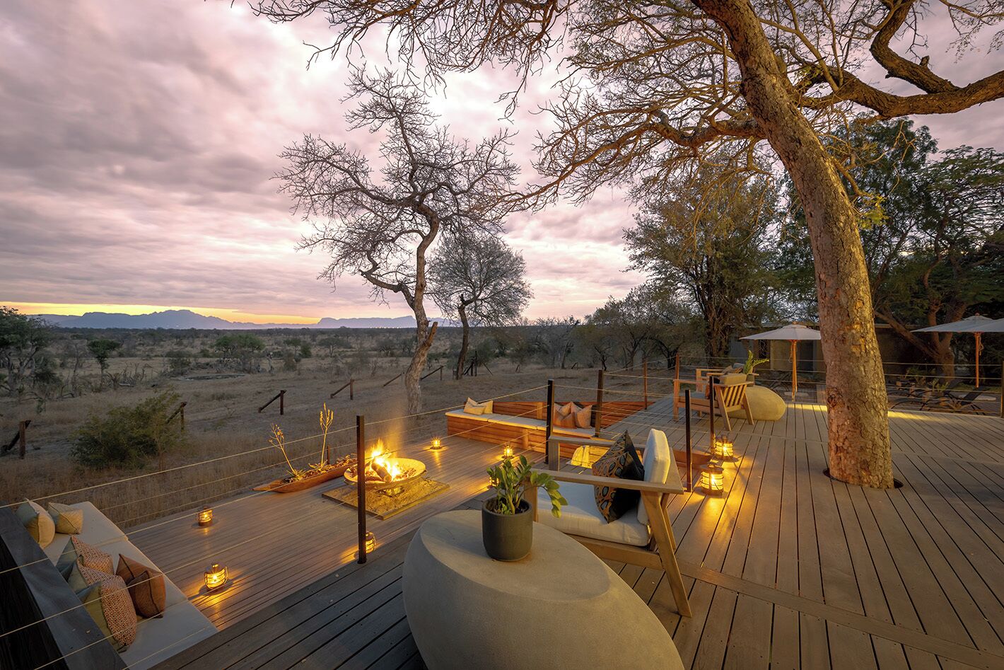 A deck with outdoor seating, a fire pit, and a view of the desert landscape.