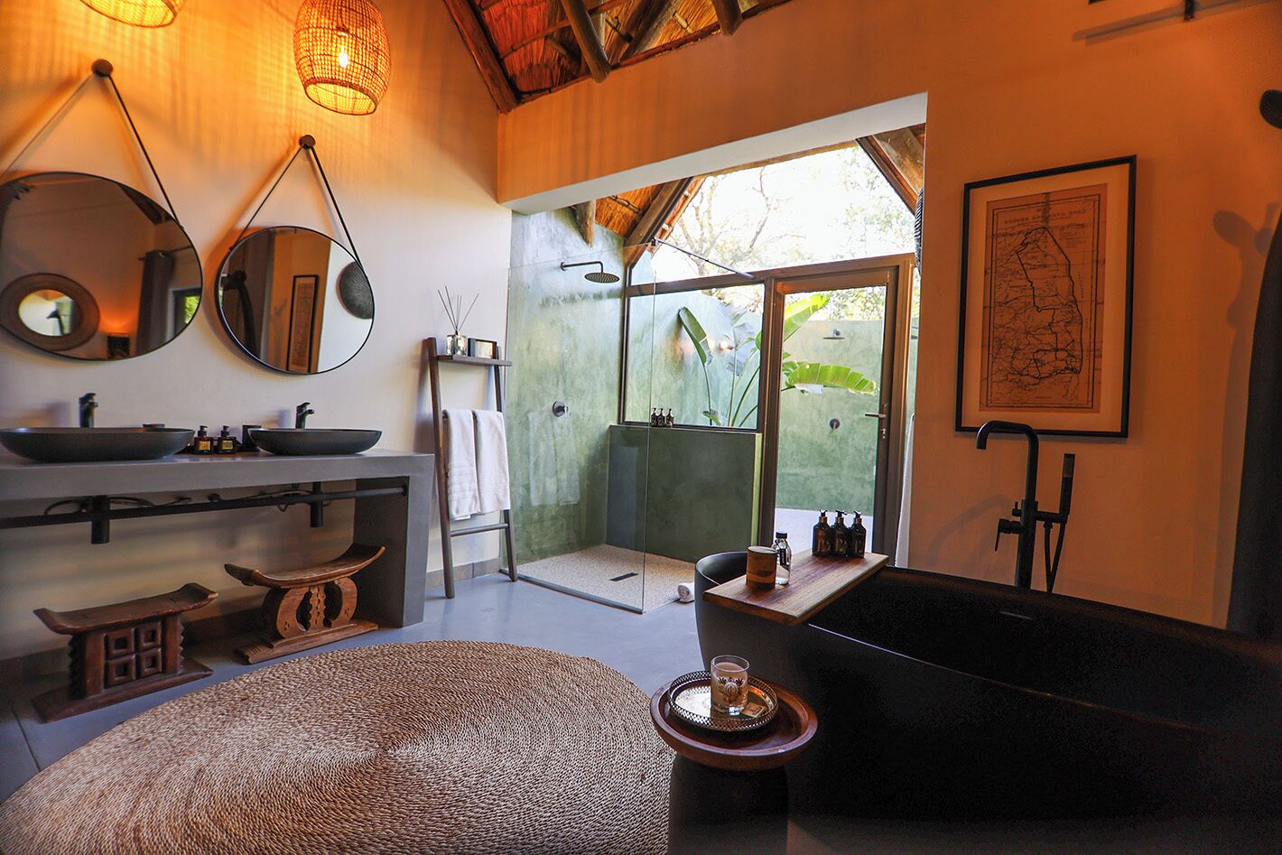 A modern bathroom with a large bathtub, a sink with two bowls, a mirror, and a shower area with a glass door.