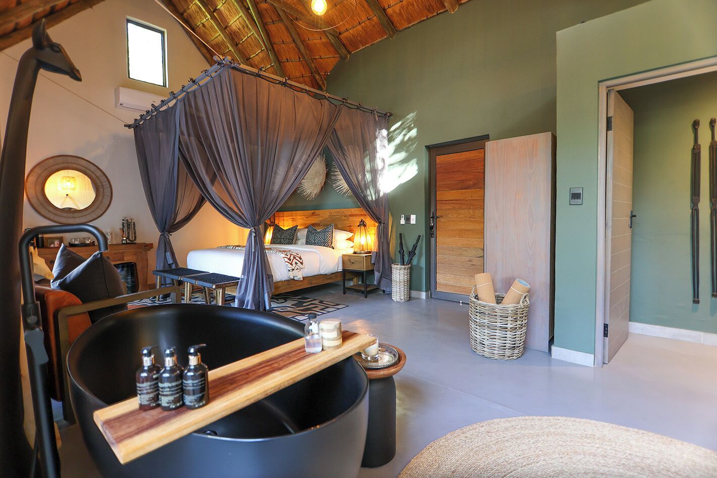 Ein geräumiges Schlafzimmer mit einem großen Bett, einer Sitzecke mit Badewanne und einem Esstisch.