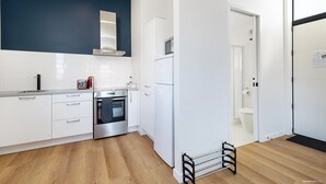A modern kitchen with white cabinets, a stainless steel oven, and a built-in microwave. - Modern One Bedroom Apartment with Lake View (Queenstown)