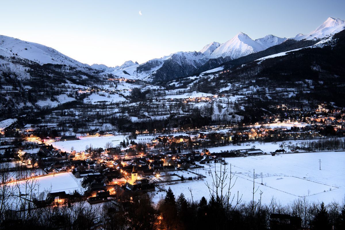 A snow-covered village with a prominent church and a mountain backdrop.
