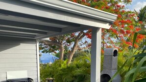 A covered outdoor area with a grill, seating, and a small water feature. - Villa close to all amenities and beach (Saint-François)