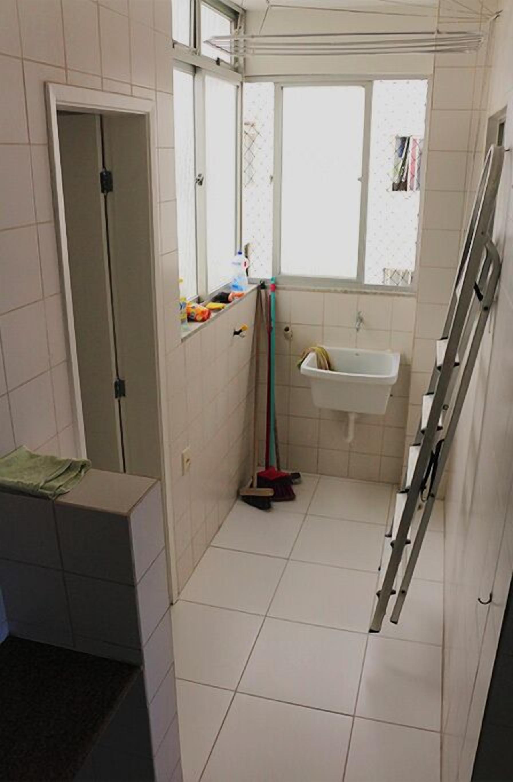 Un bagno stretto con una finestra, un lavandino e una scala.