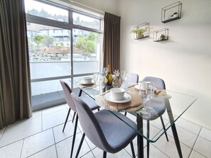 Enjoy meals with friends and family in this dining area, featuring a glass table and comfortable seating for four.