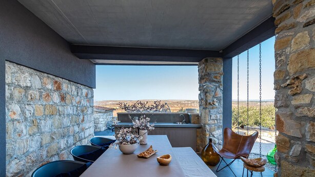 An outdoor dining area with a stone wall, a long table, and chairs. - Pet friendly home in Zagrad (Zagrad)