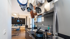A modern kitchen with a central island, stainless steel appliances, and hanging pots. - Pet friendly home in Zagrad (Zagrad)