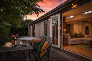 A modern house with a patio, a hot tub, and a cozy living room with a sofa and cushions.