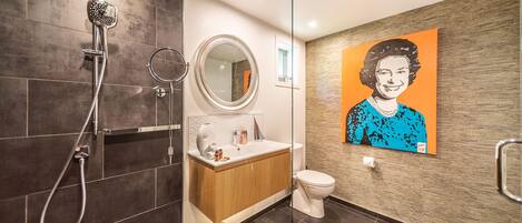 A modern bathroom with a shower, toilet, and sink.