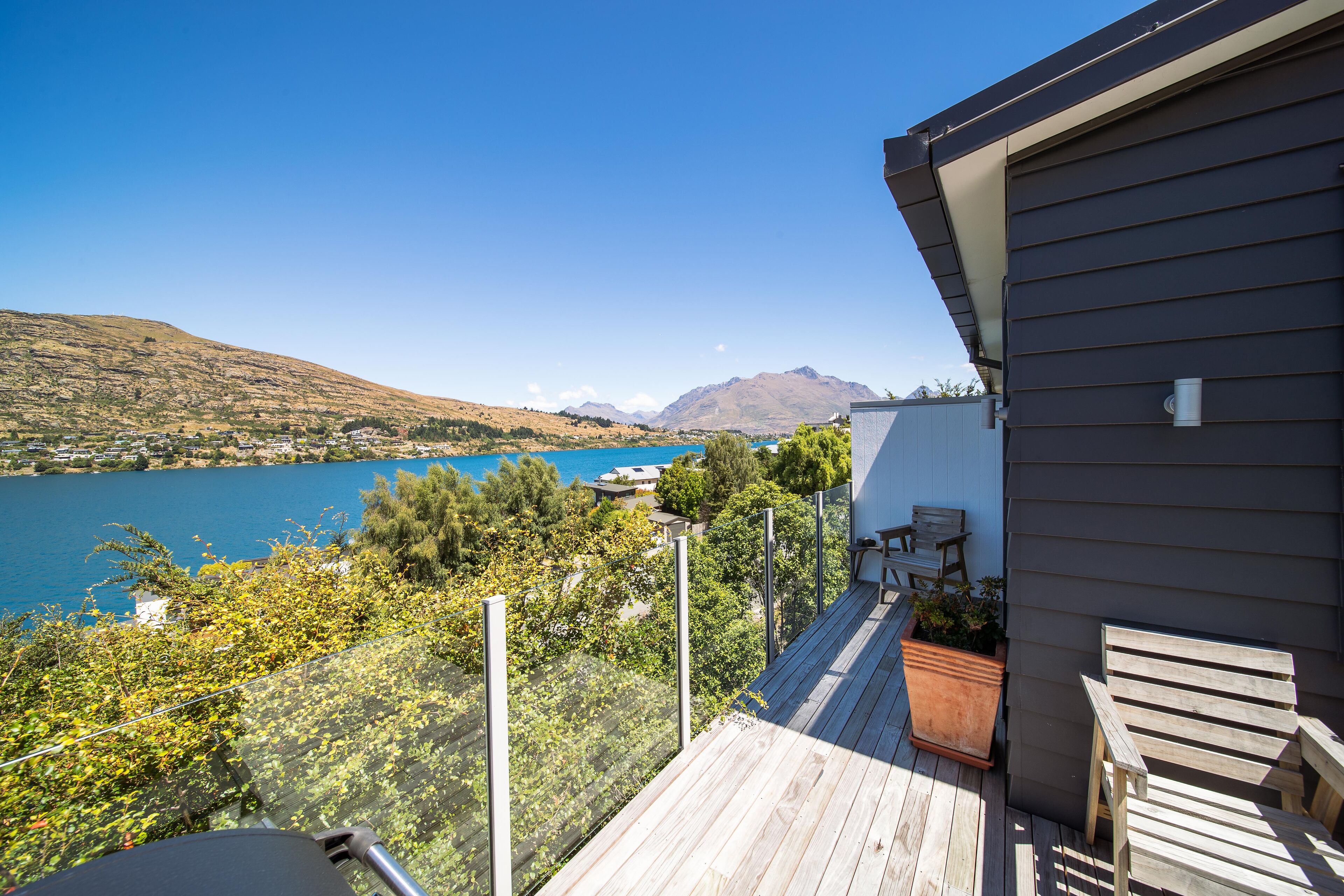 A wooden deck with a view of a lake and mountains.