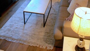 A living room with a TV, sofa, coffee table, and a painting on the wall. - Ion spacious above garage apartment in quiet neighborhood. High ceilings! (Mt Pleasant)
