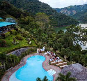 A pool surrounded by lush greenery and a mountainous backdrop. - Ecohotel Campo Alegre (Norcasia)