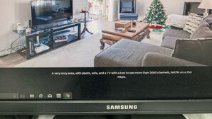 Ein Wohnzimmer mit Fernseher, Sofa und Weihnachtstannenbaum.
