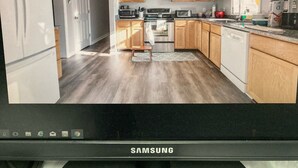 Eine moderne Küche mit Holzausstattung, Edelstahlgeräten und einem eingebauten Backofen.