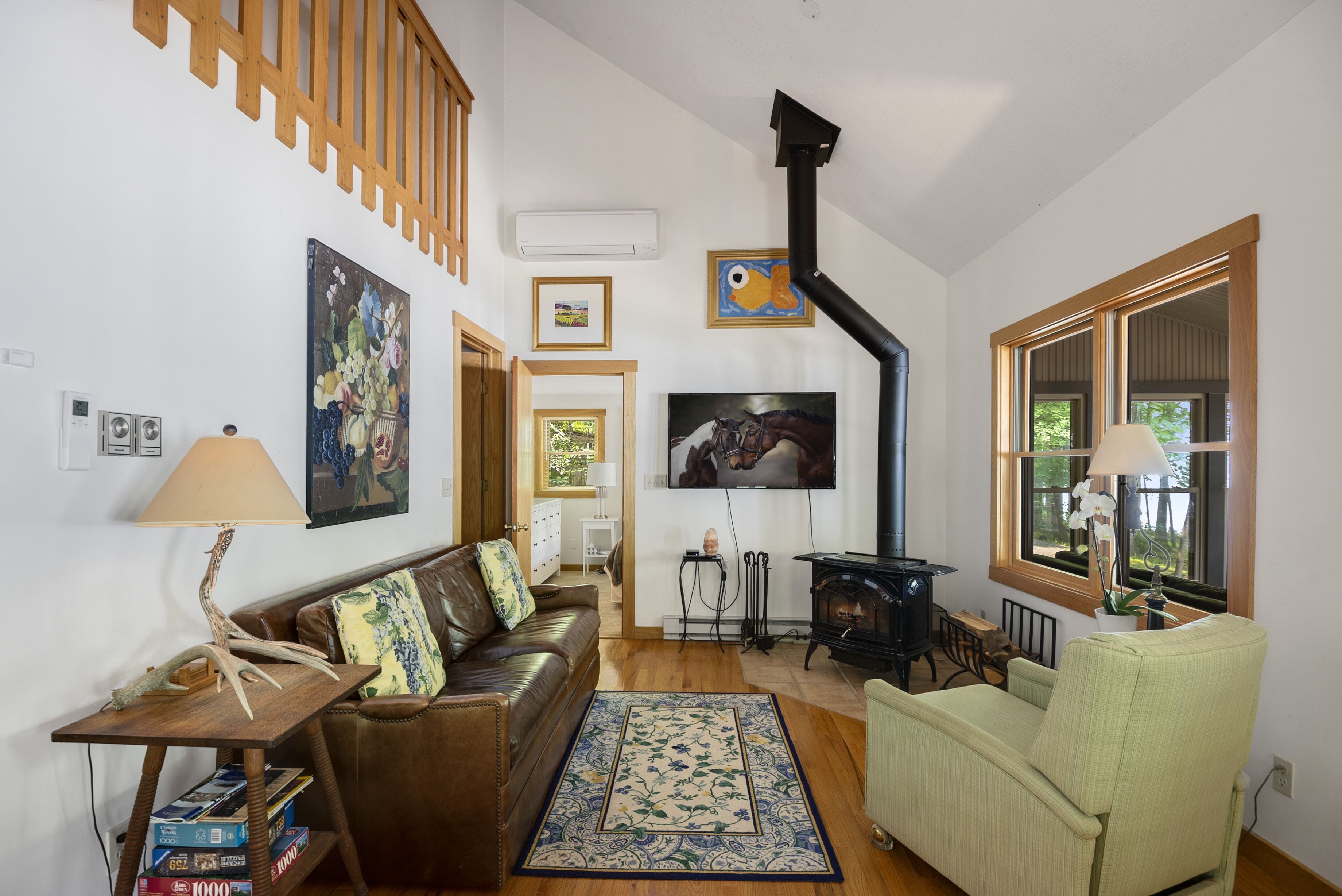 Un salón acogedor con chimenea, un sofá, un sillón verde y una mesa de centro de madera.