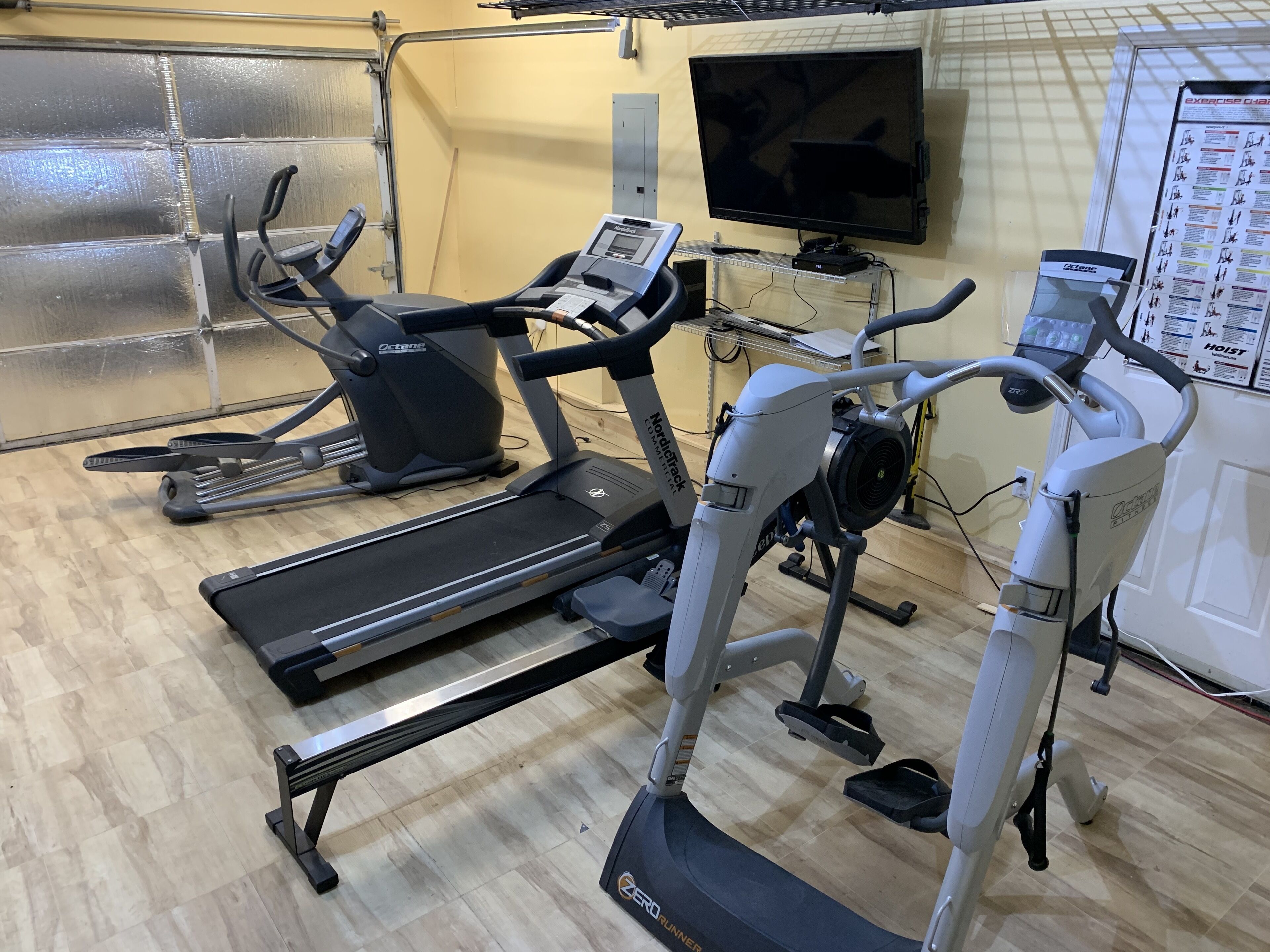 A gym with treadmills, an elliptical, and a stationary bike.