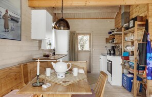 Enjoy a warm and inviting meal in this cabin's cozy kitchen and dining area, complete with a modern stove, sink, and comfortable seating.