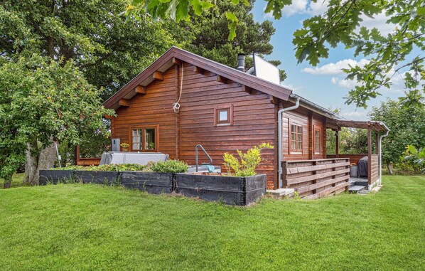 Escape to a serene cabin surrounded by lush greenery, complete with a porch and garden area.
