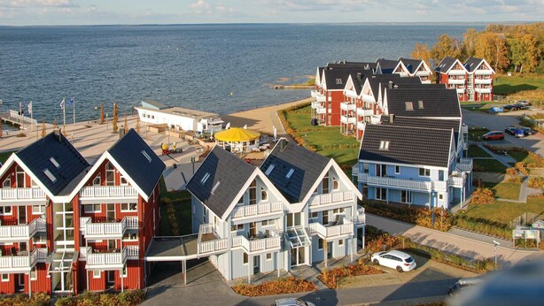 Una zona residenziale sulla costa, con case a più piani, una spiaggia e vista sul mare.
