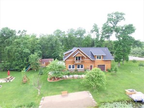 Situated in a lush green backyard, this charming home features a front porch and a well-maintained lawn.