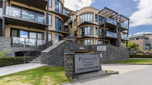 Un edificio de varios pisos con fachada de piedra, balcones y un cartel que indica que es un alojamiento de lujo llamado "Peppers Beacon".