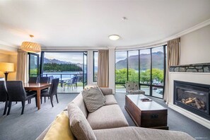 Ein Hotelzimmer mit großem Fenster und herrlichem Blick auf Berge und einen See.