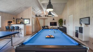 Ein Billardtisch mit blauer Spielbahn, ein Billardqueue und eine Pyramide Billardkugeln.
