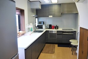 Cocina compacta equipada con microondas, cafetera y lavavajillas.