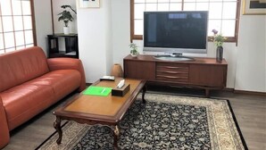 A living room with a sofa, coffee table, TV, and a cabinet. - Tokyo Yumemachi Residence Inn (Tokyo)
