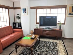 A living room with a sofa, coffee table, TV, and a cabinet. - Tokyo Yumemachi Residence Inn (Tokyo)