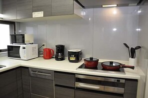 A modern kitchen with a microwave, coffee maker, and a stove. - Tokyo Yumemachi Residence Inn (Tokyo)