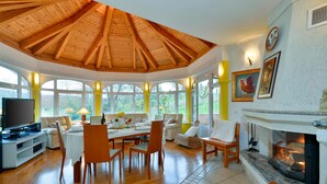 A spacious dining area with a high wooden ceiling, large windows, and a fireplace. - Nice home in Varazdin Breg with sauna (Varazdin Breg)