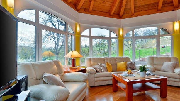 A spacious living room with a wooden ceiling, large arched windows, and a central coffee table. - Nice home in Varazdin Breg with sauna (Varazdin Breg)