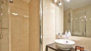 A modern bathroom with a glass-enclosed shower, a white sink, and a mirror. - The Beacon - 2 Bedroom Town Center Apartment (Queenstown)
