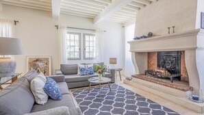 A living room with a fireplace, a sofa, a coffee table, and a patterned rug. - Stunning home in Saint-Rémy-de-Provence (Saint-Rémy-de-Provence)