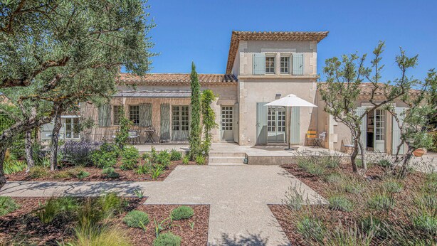 A two-story building with a tiled roof, a garden with various plants, and a paved walkway leading to the entrance. - Stunning home in Saint-Rémy-de-Provence (Saint-Rémy-de-Provence)