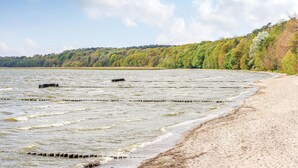 A beach with a sandy shore and calm water. - Reetdachhaus Waldidylle (Zirchow/Usedom)