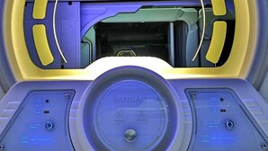 Ein futuristisches Fahrzeuginterieur mit einer zentralen Bedienkonsole mit der Aufschrift 'BANGAU' und zwei seitlichen Bedieneinheiten mit verschiedenen Schaltern und Anzeigen.