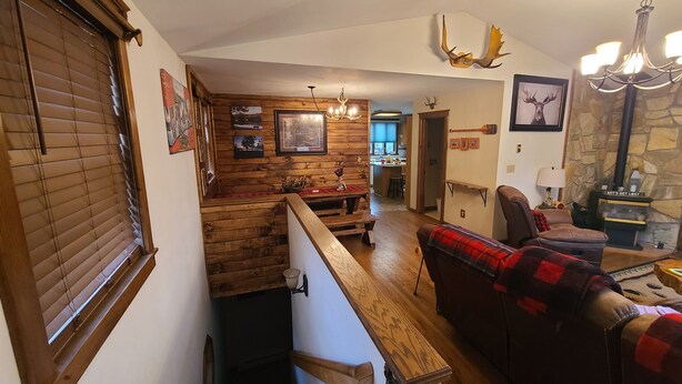 Una sala de estar acogedora con una escalera de madera, chimenea y comedor.