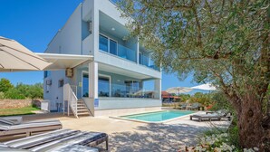 A modern two-story building with a swimming pool, outdoor seating, and a staircase leading to the entrance. - Amazing home in Fazana (Fazana)