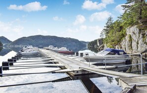 A marina with boats docked along a wooden pier, surrounded by mountains and a clear sky. - Lovely home in Lyngdal with WiFi (Lyngdal)