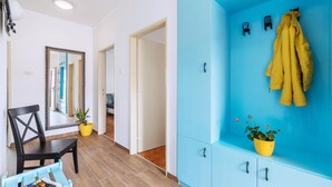 A hallway with a blue wardrobe, a mirror, a chair, and a potted plant. - Nice apartment in Fazana with WiFi (Fazana)
